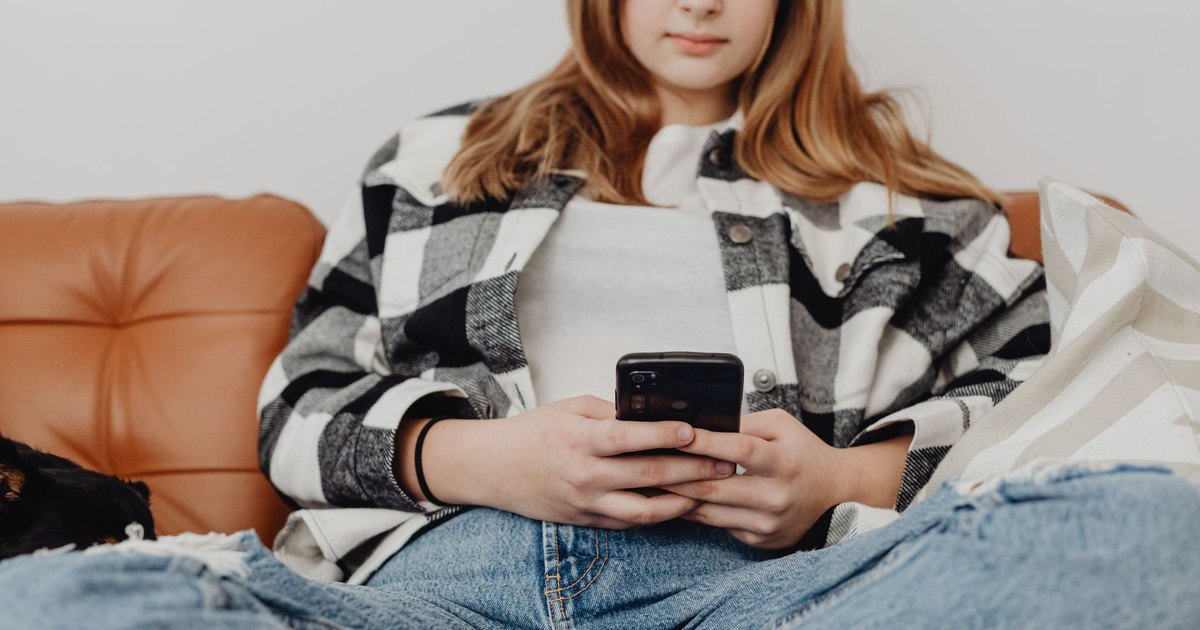 A teenager looking at a phone in the evening